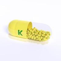 Vitamin K With Yellow Capsule, Granules and White Background photo