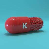 Vitamin K With Red Capsule, Granules and Turqoise Background photo