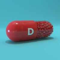 Vitamin D With Red Capsule, Granules and Turqoise Background photo