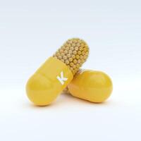 Vitamin K With Yellow Capsule, Granules and White Background photo