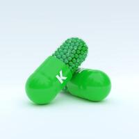 Vitamin K With Green Capsule, Granules and White Background photo