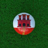 Flag of Gibraltar on a Soccer Ball with a Grass Background photo