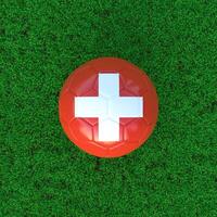 Flag Of Switzerland On Soccer Ball With Grass Background photo