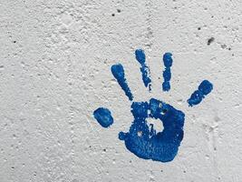 A Blue Painted Handprint on White Wall photo