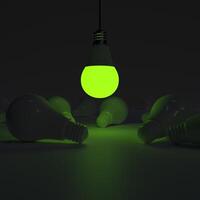 One of Lightbulb glowing among shutdown light bulb green photo