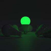 One of Lightbulb glowing among shutdown light bulb green photo