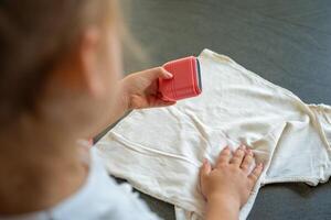 Back view of little girl with a stamp with a name for signing children's things. Identification of personal clothing. High quality photo
