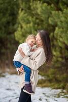 Winter portrait of happy smiling mother and little girl child, christmas time. First snow. High quality photo