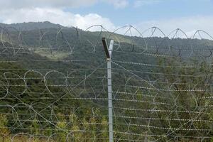 Border between Iran and Azerbaijan with barbed wire fence and mountainous landscape photo