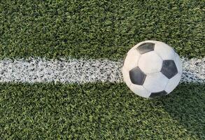 top view of football on green field, soccer ball on grass photo