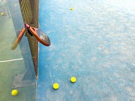 padel racket on a padel blue court with a ball photo