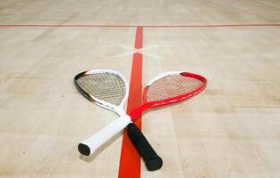 Sports, above and racket on squash court for competition, challenge and training center. Exercise, interior and empty room with top view of wooden floor of gymnasium for games, fitness club and gear photo