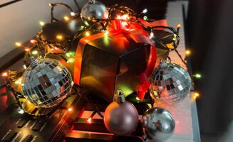 Chritmas balls and gift boxes on classical piano keyboard, front view photo