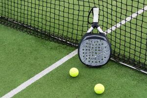 White professional paddle tennis racket with natural lighting on blue background. Horizontal sport theme poster, greeting cards, headers, website and app photo