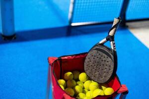 Paddle ball on racket. Yellow paddle ball laying near racket, photo