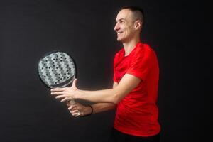 Man plays paddle tennis and poses in studio photos on white black background