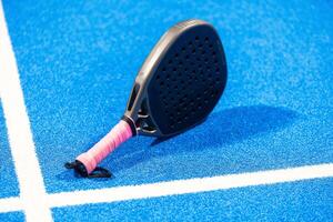 Paddle racket, next to the ball and on a carpet of the play area photo