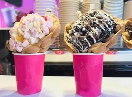 Bubble Waffle cone. Close-up of Assorted Ice Cream Cones with different flavors of ice creams, cookies and sprinkles in a Display in an ice cream Store photo