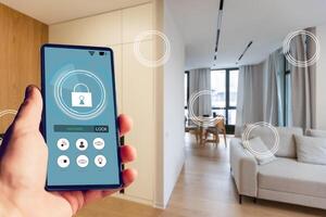 Young woman holding smart phone with launched security application at home. Concept of controlling and managing home security from a mobile device photo