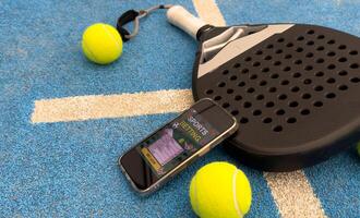 paddel racket and smartphone with bet background photo