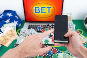 Lucky man celebrating money win. Male fan watching football play online broadcast on his laptop, cheering for his favorite team and making bets at bookmaker's website. photo
