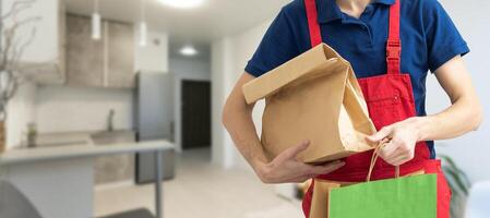 box with fast food being carried by delivery man in uniform for one of clients photo