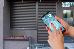 Cropped image of female entering secret key code for getting access and passing building using application on mobile phone, woman pressing buttons on control panel for disarming smart home system photo