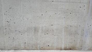 Close up of a weathered concrete surface with visible pores and grains. Ideal for industrial or rustic designs photo