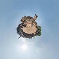 little planet and spherical aerial 360 panorama view on street ancient medieval castle with church and historic buildings with columns photo