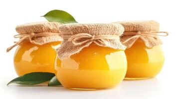 Fresh lemon curd in glass jars covered with burlap photo