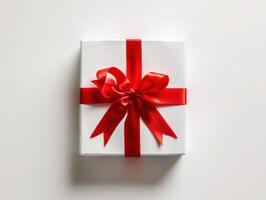 White gift box with red satin ribbon and bow photo