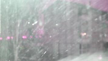 A snow covered window with a pink light video