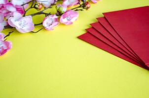 Chinese New Year decoration with red packets on yellow cover background with customizable space for text. Chinese New Year celebration photo