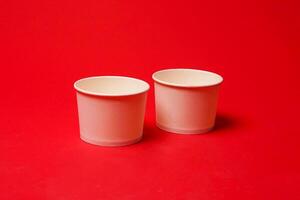 Side view of disposable kraft paper bowl, isolated on red background. High resolution photo. photo