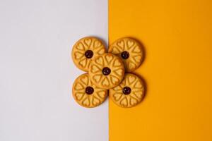 Top view of strawberry jam biscuits on a two-color background, decorated with a circular heart motif on their surface. High-resolution photo