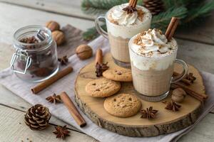 Festive holiday drinks with whipped cream and spices on a rustic wooden surface with cookies with Christmas decor photo