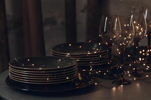 Dinner setting with set of wine glasses neatly placed on a table adorned with twinkling lights photo