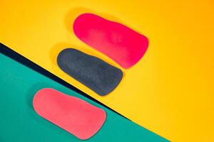 Orthopedic insoles are lined up on a wooden surface. samples of different orthopedic insoles. insoles with a variety of coating. photo
