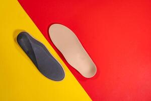 Foot support and healthy feet concept with orthopedic shoe insoles isolated on color background photo