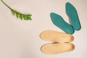 Orthopedic insoles are lined up on a wooden surface. samples of different orthopedic insoles. insoles with a variety of coating. photo