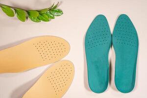 Orthopedic insoles are lined up on a wooden surface. samples of different orthopedic insoles. insoles with a variety of coating. photo