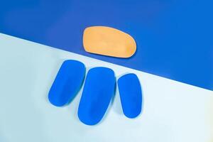 Foot support and healthy feet concept with orthopedic shoe insoles isolated on color background photo