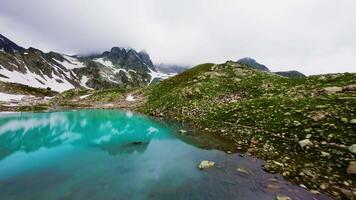 The lake is located in the Canadian Rockies, surrounded by snow-capped mountains and towering over a glacier. Crystal clear lake, cloudy weather video