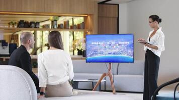 Multi-Ethnic people discussing Digital Interactive Whiteboard with real estate Data. Asian businesswoman in classic suit talking, using TV with Infographics, Statistics. AI Visualization video