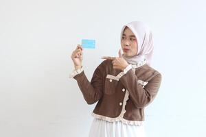 Young Woman in Hijab Showing Credit Card Online Shopping Payment Transaction photo