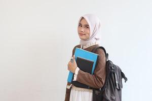 Smiling Muslim Student Girl with Books and Backpack Against White Background photo