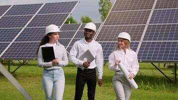 The solar farm with three engineers walk to check the operation of the system video