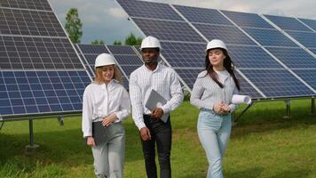 The solar farm with three engineers walk to check the operation of the system video