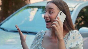 Happy laughing smiling Caucasian woman driver female auto buyer girl client cellphone user talking mobile phone online call chatting smartphone buying new car automobile rent vehicle at city street video