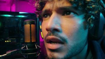 Close up face Latino Arabian man male streamer player gamer game radio presenter stream microphone excited addict cyber sport emotional recording blogger vlogger guy influencer computer studio video